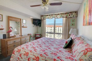 Una habitación de hotel con una cama, cómoda y televisor en la pared.