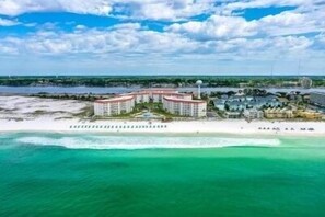 Un hôtel en bord de mer composé de plusieurs bâtiments, doté d’une plage et offrant une vue dégagée sur l’océan.