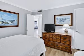 A hotel room with a bed, a dresser, a television, and two paintings on the walls. - 440 El Matador 2 Bedroom Condo by RedAwning (Fort Walton Beach)