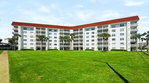 A multi-story hotel with a flat roof, balconies, and a well-maintained lawn. - 440 El Matador 2 Bedroom Condo by RedAwning (Fort Walton Beach)
