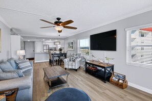 Uma sala de estar moderna com um sofá, uma mesa de centro e uma televisão.