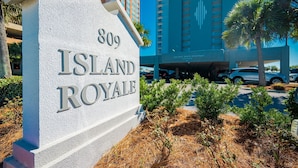 A sign for '809 Island Royale' with a modern building in the background.