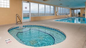 Una piscina interior con agua cristalina, un flotador salvavidas y un cartel de prohibido sumergirse.