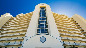 Un hotel de gran altura con múltiples balcones y una ventana vertical central.