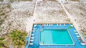 A pool area with lounge chairs and a lifeguard stand. - Driftwood Towers 6d 2 Bedroom Condo (Gulf Shores)