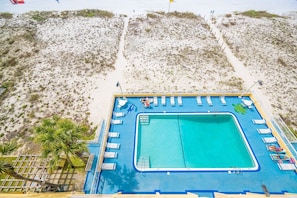 Un área de piscina con sillas de descanso y un puesto de socorristas.