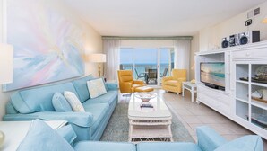 A living room with a sofa, armchairs, a coffee table, and a television. - Driftwood Towers 6d 2 Bedroom Condo (Gulf Shores)