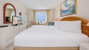 A hotel room with a large bed, a television, a desk, and a window with a view. - Driftwood Towers 6d 2 Bedroom Condo (Gulf Shores)