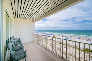 Un balcon fermé offrant une vue sur la plage.