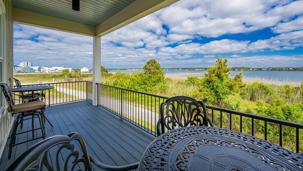 A covered outdoor area with a view of a lake and distant buildings.