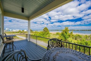 A covered outdoor area with a view of a lake and distant buildings.