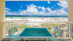 Ein Balkon mit Blick auf Strand und Meer.
