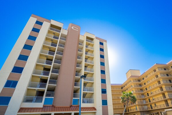 Un hotel de varios pisos con balcones y un elemento vertical central.