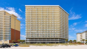 A high-rise hotel with multiple balconies, a parking garage, and a beachside location. - Seawind 905 3 Bedroom Condo (Gulf Shores)