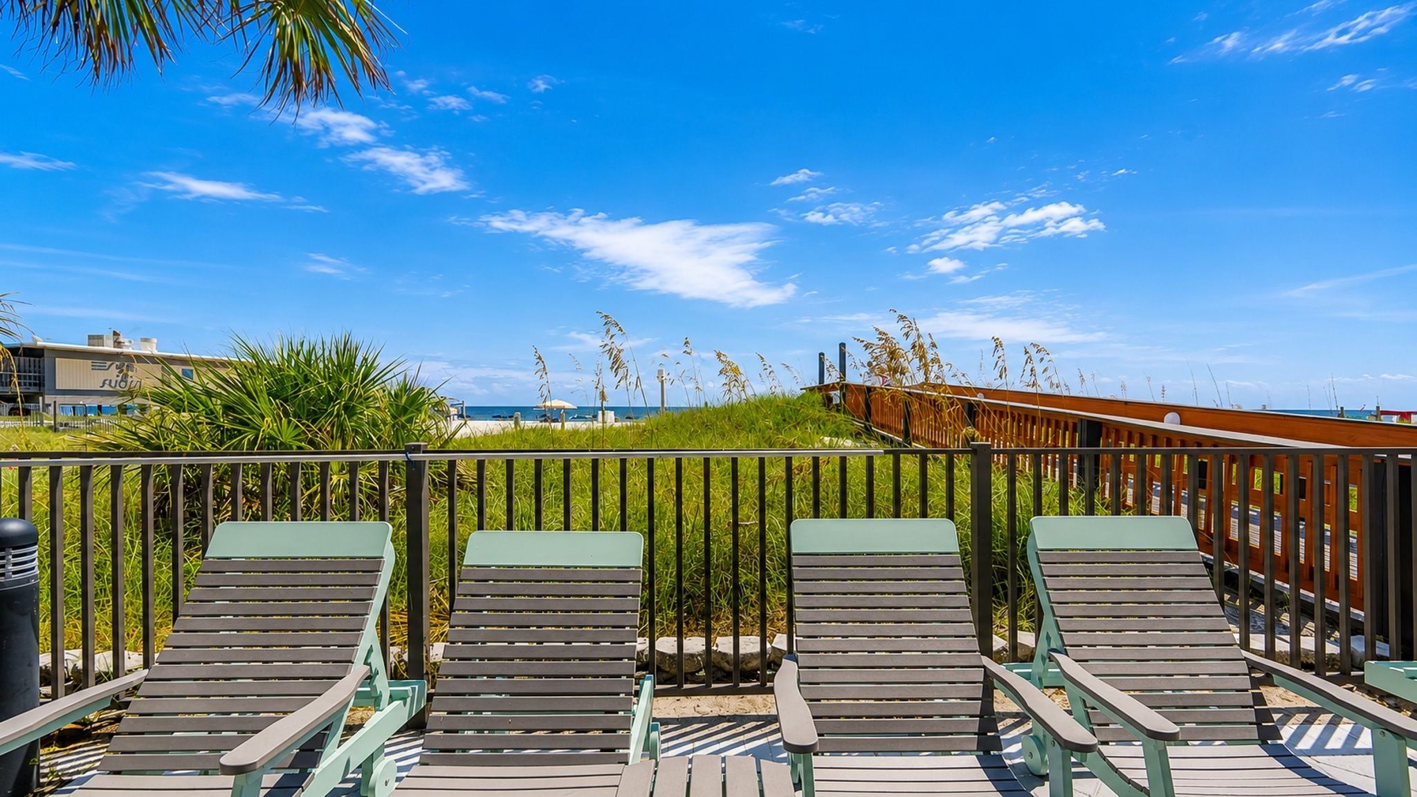 Ein Strandloungebereich mit Holzliegen und Blick auf das Meer.