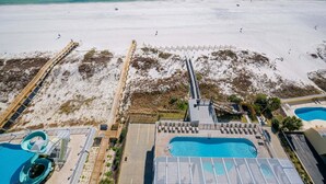 Ein Resort mit Blick auf den Strand, einem Poolbereich und einem Rettungsschwimmturm.