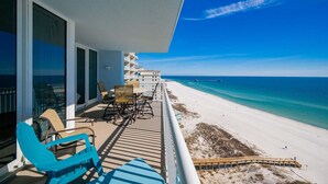 Ein Balkon mit Sitzgelegenheit und Blick auf einen Strand.