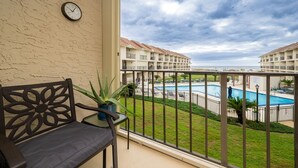 A balcony with a view of a swimming pool and hotel buildings. - Gulf Side Townhomes 20 2 Bedroom Condo (Gulf Shores)