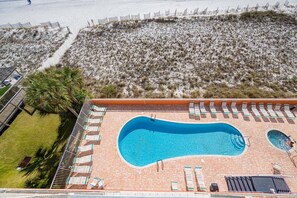 A rooftop swimming pool with a curved design, surrounded by lounge chairs and a small hot tub. - Seacrest 503 1 Bedroom Condo (Gulf Shores)