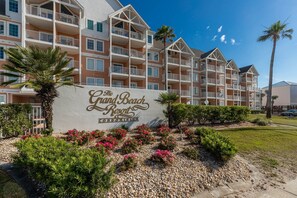 Un hôtel à plusieurs étages, doté de balcons, sur lequel on peut lire l’inscription : « The Grand Beach Resort Condominium ».