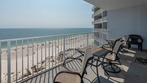 A balcony with a view of the beach and ocean. There are two chairs and a table. - Lighthouse 814 2 Bedroom Condo (Gulf Shores)