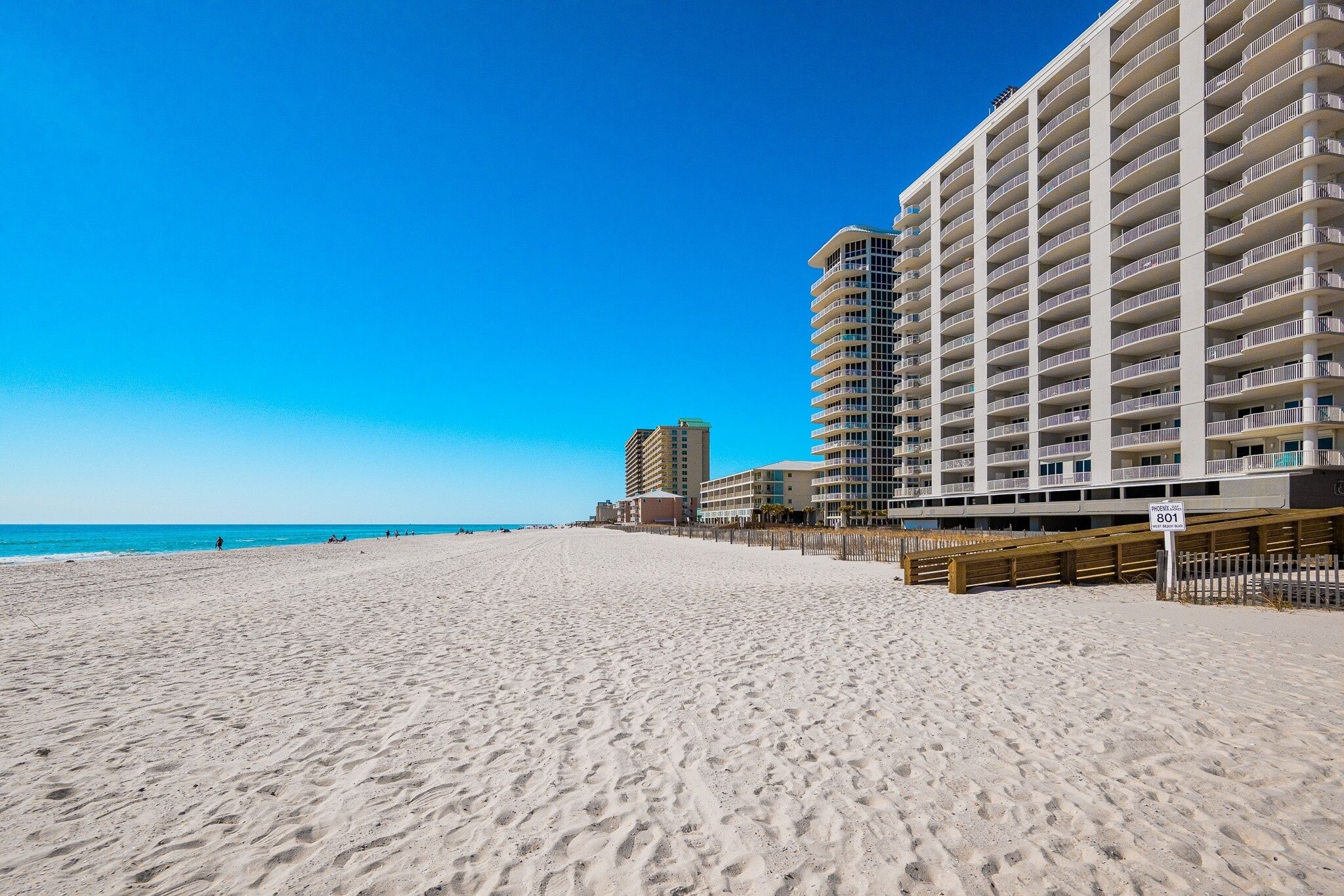 Una spiaggia con un hotel di grattacielo sullo sfondo.