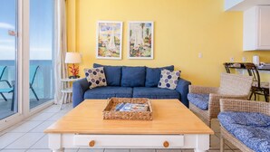 Ein Wohnzimmer mit einer Couch, einem Couchtisch mit Zeitschriften und zwei Bildern an der Wand.