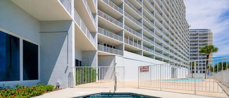 Un hôtel doté d’une piscine, de plusieurs balcons et offrant une vue sur un ciel dégagé.