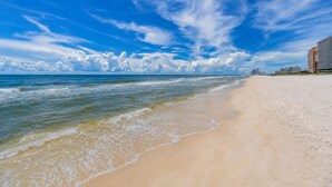 Ein Strand mit blauem Himmel und Wellen.