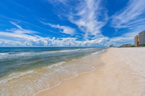 Una playa con cielo despejado y olas del océano.