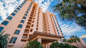 A tall, multi-story hotel with a modern design, featuring balconies on each floor and a covered entrance area. - Sea Chase 505c 3 Bedroom Condo (Orange Beach)