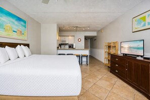A hotel room with a large bed, a kitchenette, a TV, and artwork on the walls. - Sugar Beach 177 1 Bedroom Condo (Gulf Shores)