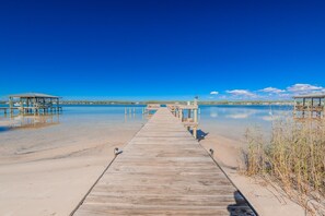 A wooden pier leading to a beach with clear blue water and a calm sky. - Summer House West 104c 1 Bedroom Condo (Gulf Shores)