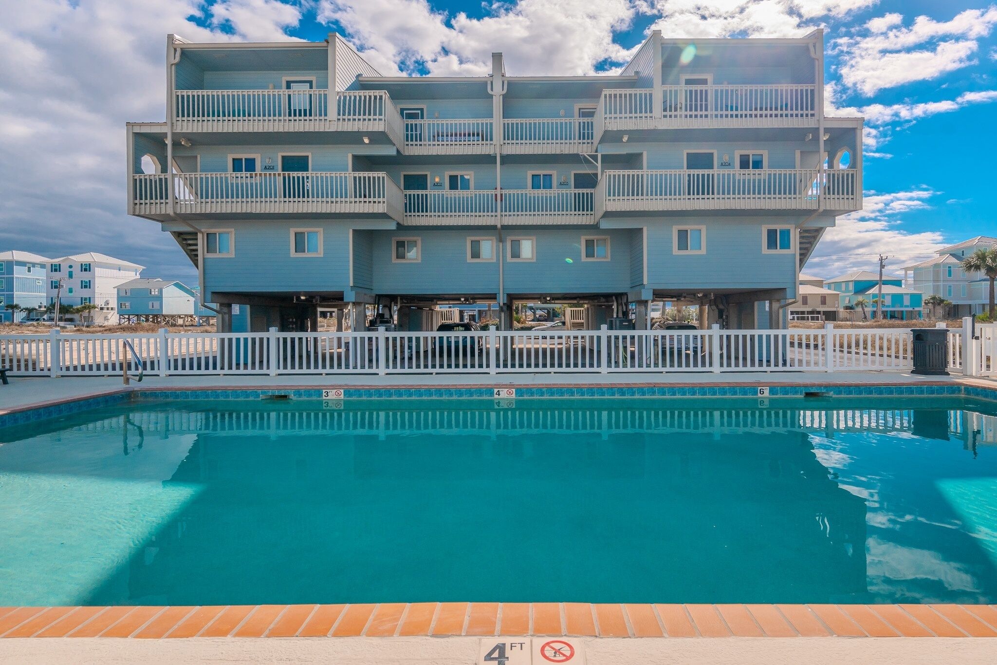 A multi-story building with a swimming pool in front.