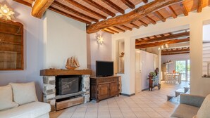 Ein Wohnzimmer mit Kamin, Fernseher und Sitzgruppe.