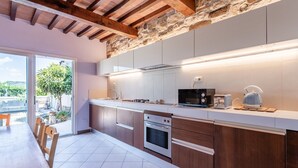Eine moderne Küche mit Holzausbau, einer Steinwand und einem Essbereich mit Tisch und Stühlen.