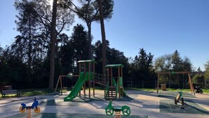 A playground with a slide, swings, and a seesaw. - Quiet & Cosy Colosseum (Roma)