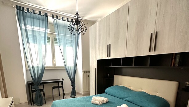 A bedroom with a bed, a desk, and a chair. - Quiet & Cosy Colosseum (Roma)