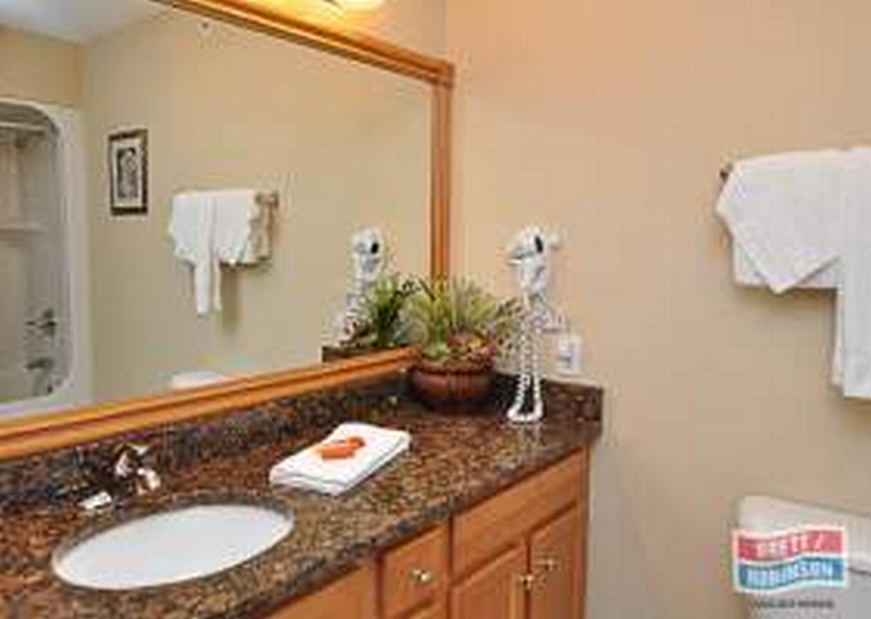 A bathroom with a sink, mirror, and a towel rack.