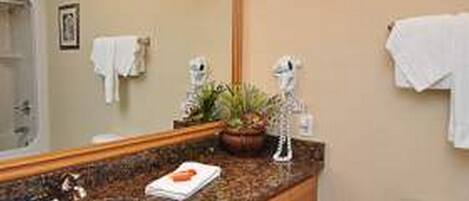A bathroom with a sink, mirror, and a towel rack.