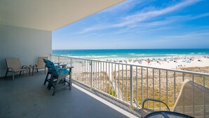 Un balcon avec des chaises et vue sur la plage.