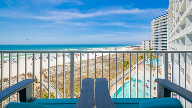 Un balcon avec vue sur une plage et une piscine.