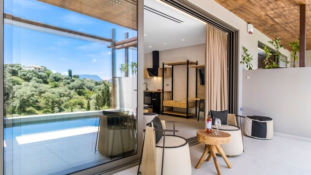 Een modern interieur met een glazen wand, een zwembad en een eethoek met uitzicht.