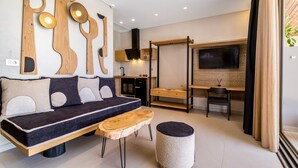 Een moderne woonkamer met een bank, houten bijzettafeltje, poef en abstracte wanddecoratie.