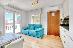 Une cuisine moderne avec une porte en bois, un canapé bleu et une table à manger avec des chaises.
