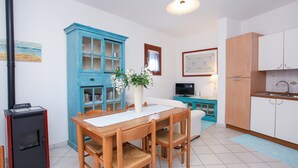 Una cocina moderna con comedor, un armario azul, un refrigerador blanco y una estufa a leña.