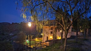 A building with a rustic exterior, surrounded by trees and a dirt path.