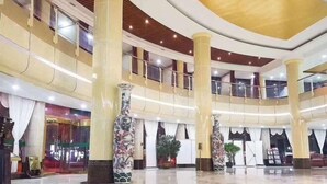 A spacious lobby with high ceilings, large columns, and a central atrium.