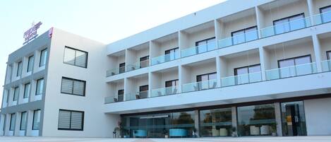 Un edificio moderno con varios balcones y ventanas amplias.