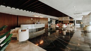 A modern lobby with a reception desk, seating area, and a polished marble floor. - Pride Resort Ranakpur. (Desuri)